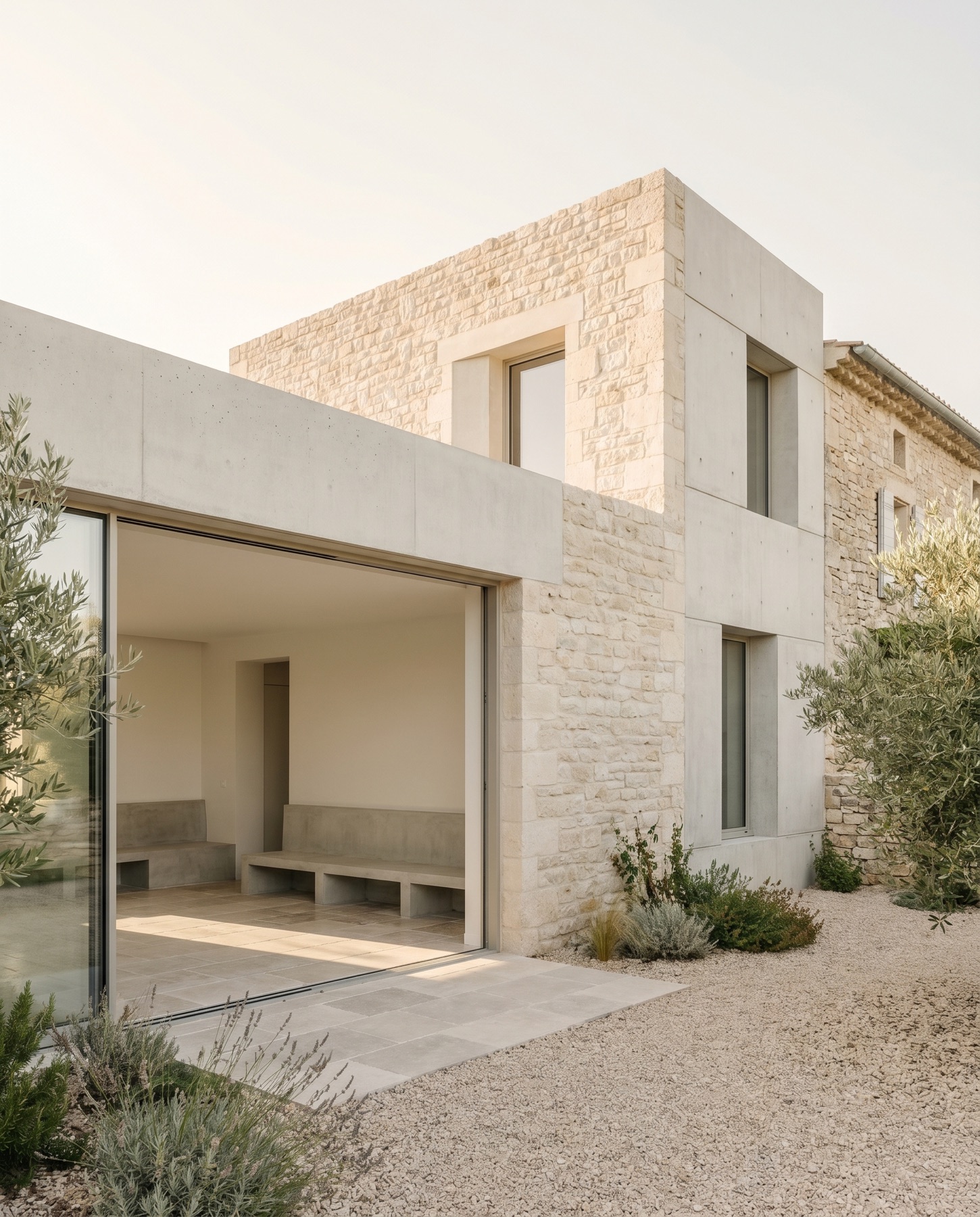 Extension maçonnée, pierre claire et béton lisse, grande ouverture.